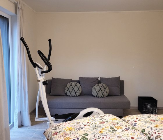 Schlafzimmer mit Hometrainer und Sofa Schlafzimmer mit Hometrainer und Sofa
