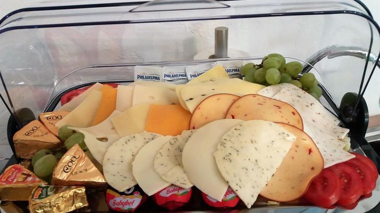 Eine Auswahl an verschiedenen Käsesorten mit Trauben, Tomaten und kleinen Käseportionen. Auf einem schönen Teller serviert, präsentiert es eine appetitliche Platte für einen Snack oder eine Party.