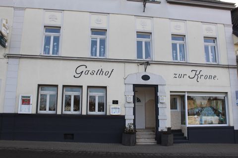Ein Gasthof mit dem Namen "zur Krone" ist zu sehen. Das Gebäude hat mehrere Fenster und eine einladende Fassade.