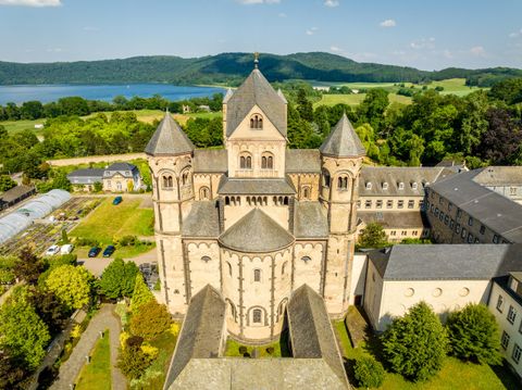 Eine beeindruckende Kirche mit mehreren Türmen und einem klaren blauen Himmel. Der Grünbereich um die Kirche lädt zum Verweilen ein.