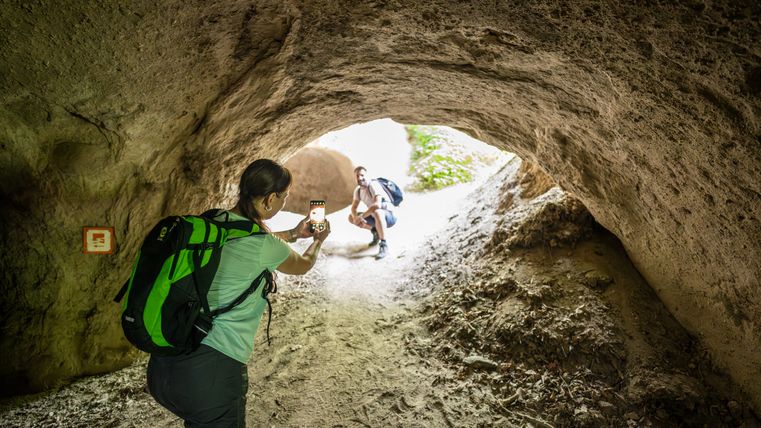 Person fotografiert eine andere Person in einer Höhle mit einem Smartphone.