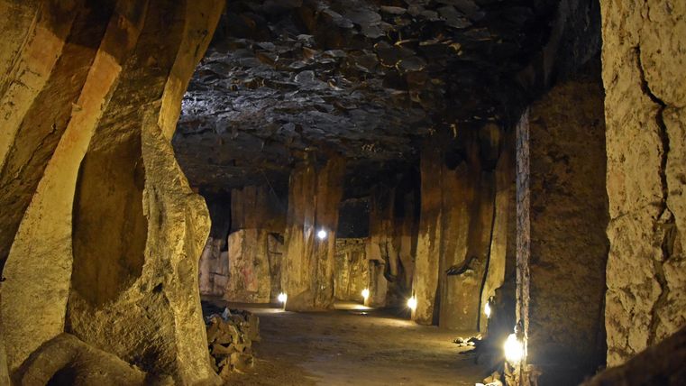 Eine beeindruckende Höhle mit hohen Wänden aus Stein und sanfter Beleuchtung. Der Raum wirkt geheimnisvoll und weitläufig.