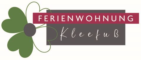 A logo for the vacation apartment Kleefuß. It features a stylized flower in green and black with pink lettering.