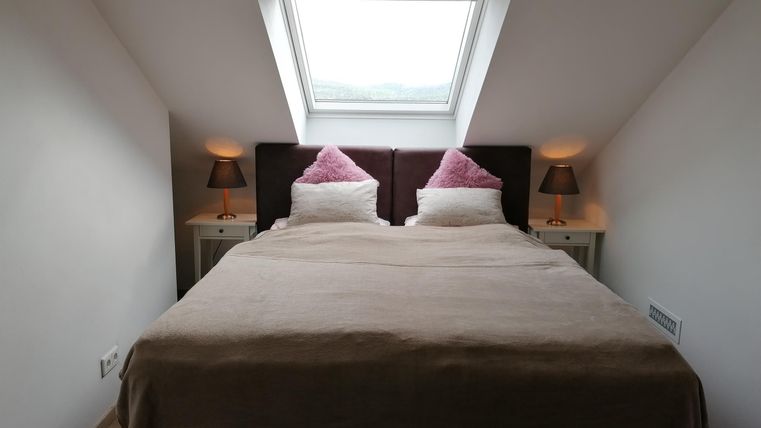A cozy bedroom with a double bed and two nightstands. The roof window provides plenty of daylight.