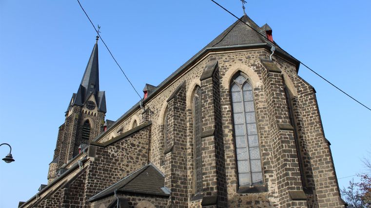Eine beeindruckende Kirche mit einem hohen Turm und großen Fenstern. Der klare Himmel verleiht der Szene eine ruhige Atmosphäre.
