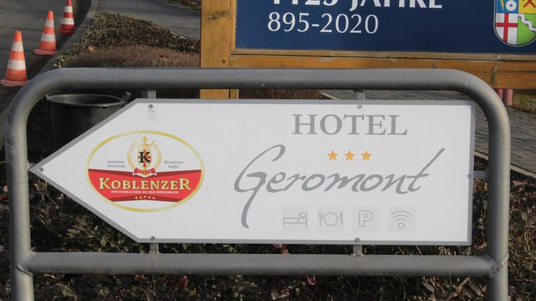 Ein Hinweisschild zeigt die Richtung zu dem Hotel Geromont. Das Schild ist gut sichtbar und enthält das Logo der Köche.