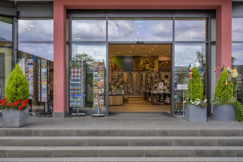 An inviting store with large windows and many postcard displays. Inside, there are additional products and appealing decor on display.