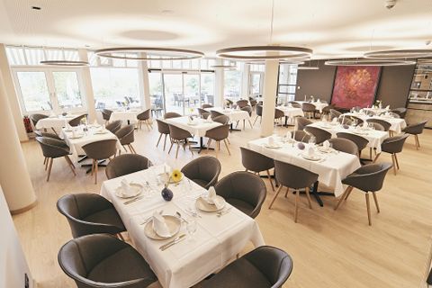 Ein elegantes Restaurant mit stilvollen Tischen und Stühlen. Die Innenarchitektur ist modern und einladend, ideal für besondere Anlässe.