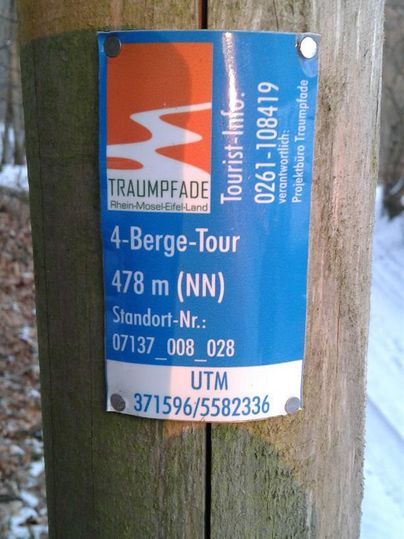 Ein Informationsschild über die 4-Berge-Tour mit einer Höhe von 478 m. Es befindet sich an einem Holzpfosten im Freien.