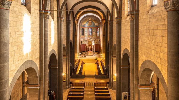 An impressive church with high, vaulted ceilings and elegant pews. The altar area is well-lit and attracts attention.