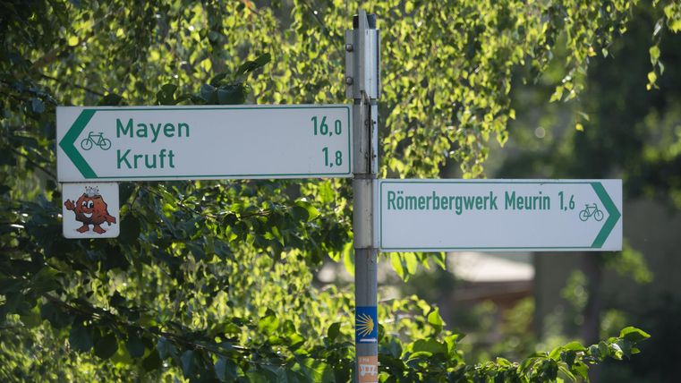 Ein Verkehrsschild mit Richtungsanzeigen für Mayen und Kruft. Die Entfernungen sind in Kilometern angegeben.