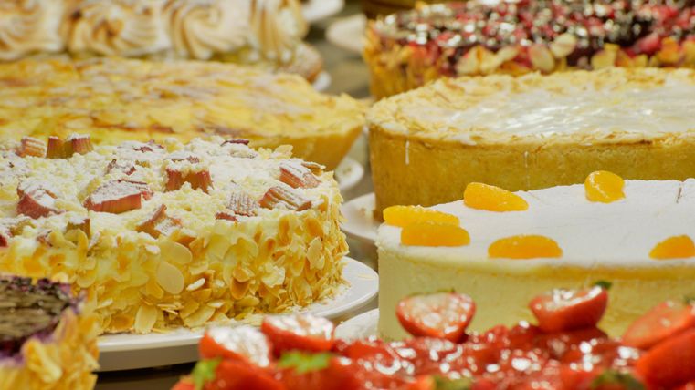 A selection of delicious cakes with various toppings and fruits. The cakes are colorfully and invitingly arranged.
