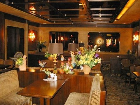 An elegant restaurant with cozy seating areas and stylish decoration. Floral arrangements and decorative figures adorn the tables.