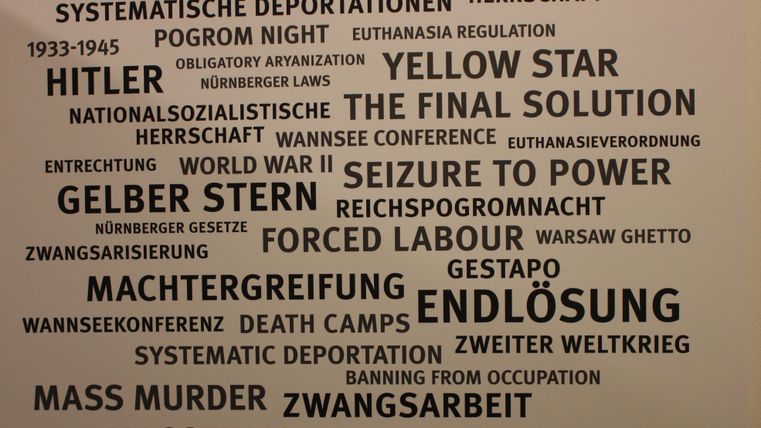 Eine Wand mit Begriffen, die mit dem Nationalsozialismus und dem Holocaust in Verbindung stehen. Die Worte stammen aus verschiedenen historischen Kontexten und Ereignissen.