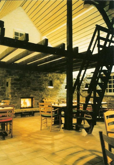 A cozy interior view with wooden furniture and a fireplace. The atmosphere is warm and inviting.
