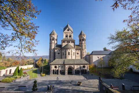 Een indrukwekkende kerk met meerdere torens en een heldere blauwe lucht. Het groenoppervlak rondom de kerk nodigt uit om te verblijven.