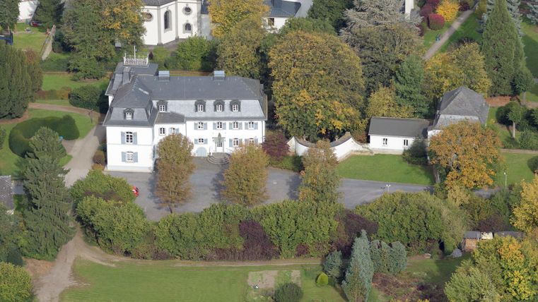 A beautiful property surrounded by trees and colorful bushes. The garden is well-kept and invites you to linger.