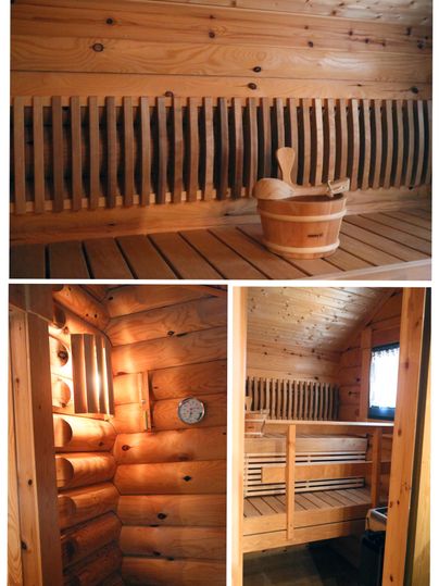 A cozy sauna with a wood stove and a wooden attachment. In the middle, there is a bucket and a ladle.