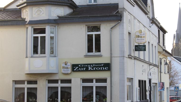 A restaurant named "Zur Krone" on a corner. The facade is bright and has large windows.