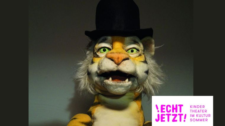 Ein fröhlicher Tiger mit einem Zylinderhut. Der Tiger hat ein aufgeregtes Gesicht und ist Teil eines Kinderprogramms.