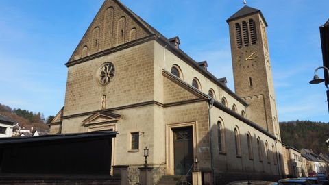 A historic church with a tall tower and a striking facade. The sky is clear and blue.