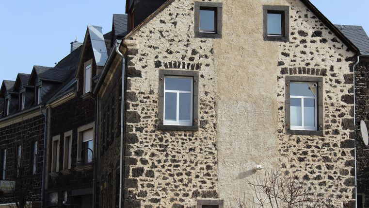 Ein attraktives Haus mit einer interessanten Fassade ausSteinen und Mauern. Die Fenster sind schlicht und harmonisch in das Design integriert.