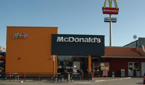 A McDonald's restaurant with a McCafé area. In the background stands the famous McDonald's symbol.