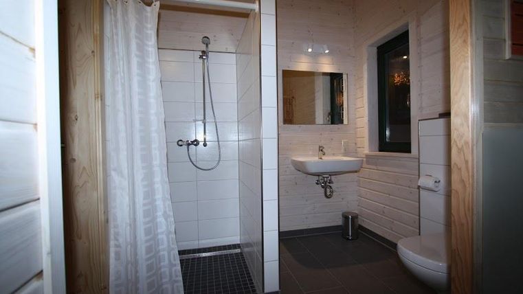 Ein modernes Badezimmer mit einer Dusche, einem Waschbecken und einem WC. Die Wände sind hell und die Ausstattung ist funktional.